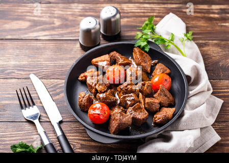 Roasted or stewed beef meat with tomato in pan Stock Photo