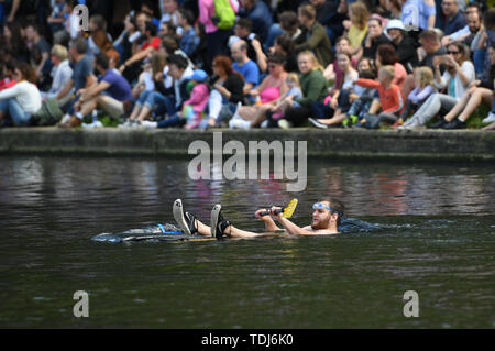 Cambridge University students in boats made from cardboard float down the River Cam in Cambridge on the Suicide Sunday, part of the annual traditions to celebrate the end of exams. Stock Photo