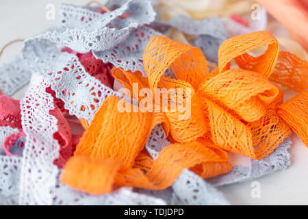 Beautiful lace ribbons lie on the table of a seamstress to create unique women's and children's dresses. The concept of designer clothing to order. Stock Photo