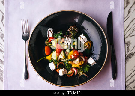 Appetizing dish in the restaurant, serving on the table with a lilac tablecloth. Stock Photo