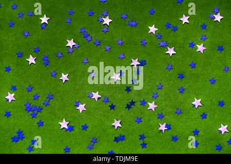 Blue and silver sparkles stars on a bright green background.  Stock Photo