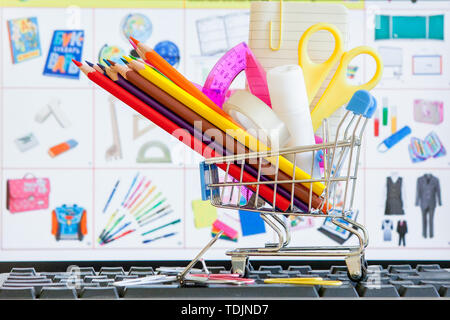 Shopping cart full of school tools on the keyboard, online shopping concept. Stock Photo