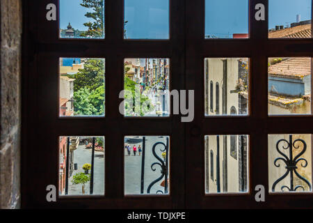 View through the window of church tower of the historic town of San Cristobal de La Laguna in Tenerife showing the buildings and streets with mountain Stock Photo