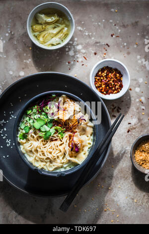 Asian dinner set: ramen noodle soup with pork dumplings served in a bowl Stock Photo