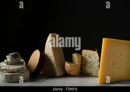 A selection of cheeses on a marble tile surface. Stock Photo