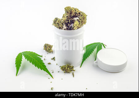 white container with Cannabis flower buds and cannabis leafs isolated on white, medical marijuana concept Stock Photo