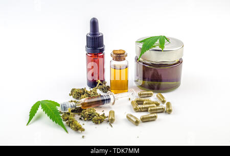 CBD cannabidiol oil glass bottles, pills flower buds and Cannabis leafs isolated on white Stock Photo