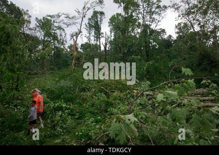 Katie Francke stands with her grandson outside her granddaughter's home, which was damaged during a tornado Saturday, on W. Chafin Chapel Rd., Sunday, June 16, 2019 near Ellettsville, Ind. A tornado struck the area Saturday night leaving a patch of damage from Greene County to Northern Monroe County destroying trees, homes, cars, and leaving a path of debris and live power lines on the ground in its wake. during the aftermath. Katie Francke stands outside her granddaughter's damaged home, during the aftermath. A tornado struck the area leaving a patch of damage from Greene County to Northern M Stock Photo