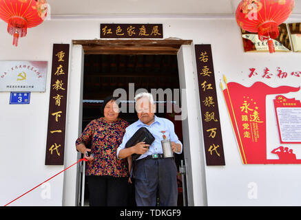 Changting. 16th June, 2019. Photo taken on June 16, 2019 shows Zhong Yilong (R), a 91-year-old retired cadre, walking out of his home with the support of his daughter-in-law at the Changketou Village of Nanshan Town in Changting County, southeast China's Fujian Province. Since 1953, Zhong Yilong collected the names of martyrs who participated in revolution from 1928 to 1934. He also set up an exhibition regarding the Red Army at his ancestral house several years ago to pass the history down. Credit: Wei Peiquan/Xinhua/Alamy Live News Stock Photo