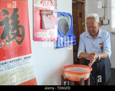 Changting. 16th June, 2019. Photo taken on June 16, 2019 shows Zhong Yilong, a 91-year-old retired cadre, washing his hands at the Changketou Village of Nanshan Town in Changting County, southeast China's Fujian Province. Since 1953, Zhong Yilong collected the names of martyrs who participated in revolution from 1928 to 1934. He also set up an exhibition regarding the Red Army at his ancestral house several years ago to pass the history down. Credit: Li Renzi/Xinhua/Alamy Live News Stock Photo