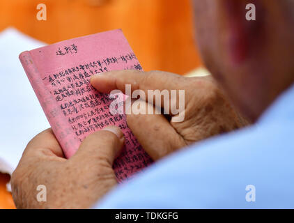 Changting. 16th June, 2019. Photo taken on June 16, 2019 shows Zhong Yilong, a 91-year-old retired cadre, reading his notebook at the Changketou Village of Nanshan Town in Changting County, southeast China's Fujian Province. Since 1953, Zhong Yilong collected the names of martyrs who participated in revolution from 1928 to 1934. He also set up an exhibition regarding the Red Army at his ancestral house several years ago to pass the history down. Credit: Wei Peiquan/Xinhua/Alamy Live News Stock Photo