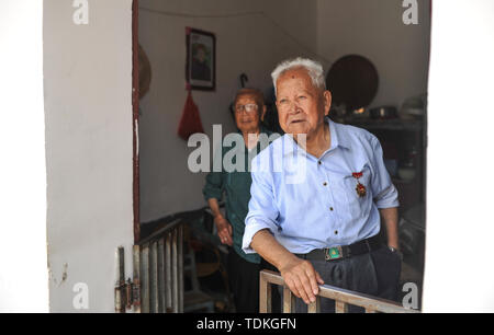 Changting. 16th June, 2019. Photo taken on June 16, 2019 shows Zhong Yilong, a 91-year-old retired cadre, and his wife standing at their home in the Changketou Village of Nanshan Town in Changting County, southeast China's Fujian Province. Since 1953, Zhong Yilong collected the names of martyrs who participated in revolution from 1928 to 1934. He also set up an exhibition regarding the Red Army at his ancestral house several years ago to pass the history down. Credit: Li Renzi/Xinhua/Alamy Live News Stock Photo