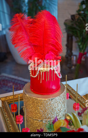 Red and golden cake. Feather cake. Cake with pearl beads on top. Stock Photo