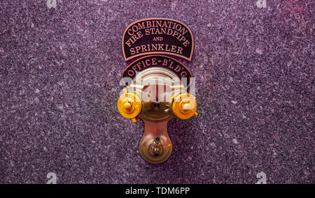 Fire standpipe outdoors on an office building stone facade, New York, Manhattan downtown Stock Photo