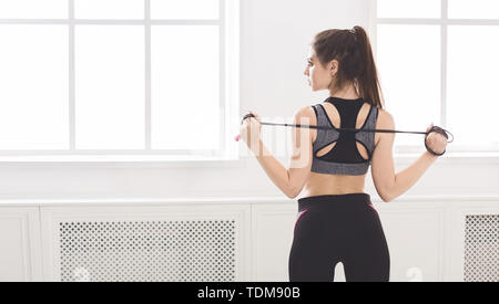 Fit girl standing with skipping rope in studio Stock Photo