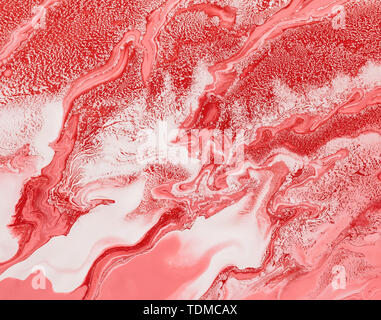 Acrylic Fluid Art. Mixing red, white and coral acrylic paints. Abstract marble background or texture. Stock Photo