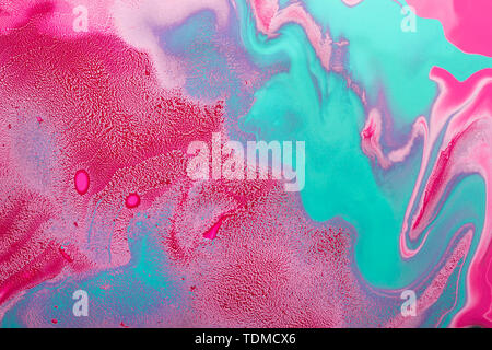 Acrylic Fluid Art. Turquoise curls on red waves and pink inclusions. Abstract modern background or texture. Stock Photo