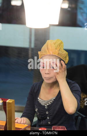 Traditional Chinese actress, applies makeup before a performance in a Chinese theatre. Photographed in Chengdu, Sichuan, China Stock Photo