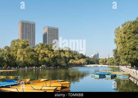 Autumn China Fushun early morning park river bank willow stone bridge cruise ship Stock Photo