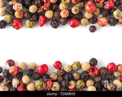 Mixed peppercorns background with white copy space in center. Food background with peppercorns. Different colored peppercorns pattern on white background, top view or flat lay Stock Photo