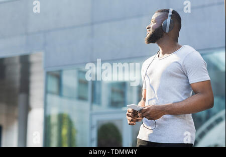 Young thoughtful african american guy walking outdoor Stock Photo