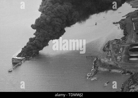 Smoke pours from the partly submerged wreck of the French tanker Betelgeuse, which was ripped apart on Monday, January 8th by a series of explosions as she was unloading 120,000 tonnes of crude oil at the Gulf Oil Terminal in Bantry Bay, Ireland. Fifty people died - including 43 of the crew of the 60,000-ton tanker. Stock Photo