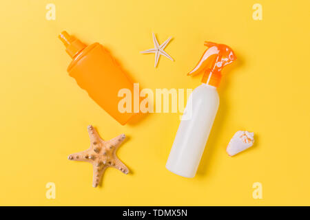 sunscreen cream with starfish and seashells in bottles on yellow ...