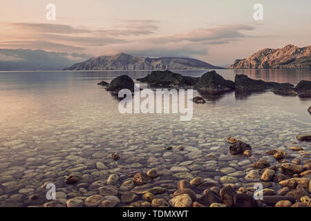 Amazing beach sunset with mountain in the distance, and stars over the sky in Croatia Stock Photo