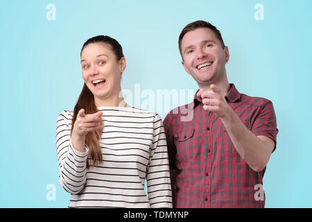 couple man and woman laughing pointing at you Stock Photo