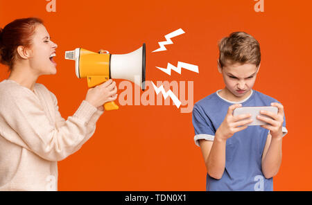 Gadget addicted boy playing mobile games on cellphone Stock Photo