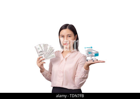 retail commercial business concept, Asian beautiful woman holding banknote money in hand and shopping cart in another hand isolated on white backgroun Stock Photo