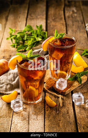Iced tea and ingredients in glasses on wood background Stock Photo