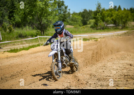 KHABAROVSK, RUSSIA - june 16, 2019 : Racer child on motorcycle participates in motocross cross-country in flight, jumps and takes off on springboard a Stock Photo