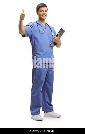 Full length portrait of a young male doctor holding a clipboard and showing thumbs up isolated on white background Stock Photo