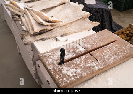 Dried salted cod and cutting board at farmers market Stock Photo