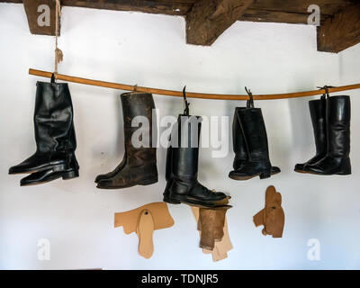 View on traditional leather boots hanged on a rope. Stock Photo