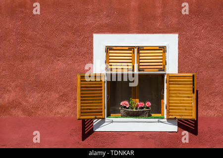 Open wooden window shutter on red wall, Koszeg, Hungary Stock Photo
