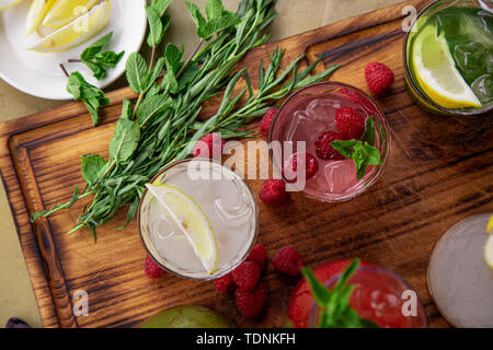 Summer soft drinks, a set of lemonades. Lemonades in jugs on the table, the ingredients of which they are made are arranged around. Stock Photo