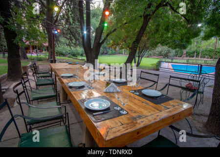 Wooden table with fancy dishes and wine glasses outside Stock Photo
