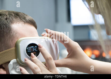 Relax and massage, electric eye massager on the concept of men, closeup. Programming Stock Photo
