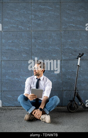 Businessman sitting cross legged outdoors meditating Stock Photo - Alamy