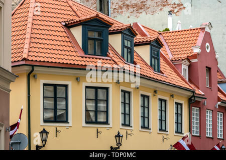 House with yellow walls, with attics on the roof of red tiles in the old part of Riga. Stock Photo