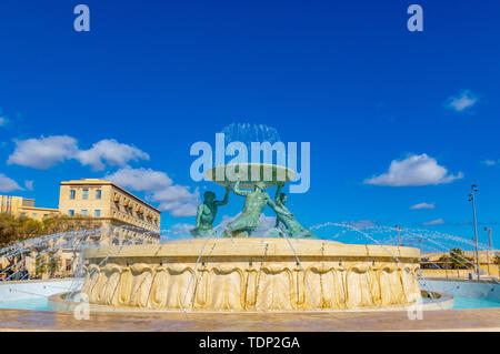 The famous Triton fountain, three bronze Tritons holding up a huge basin, in front of the City Gate in Valletta, sizable landmark fountain featuring m Stock Photo