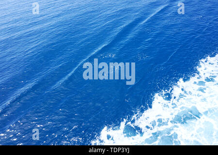 Abstract nature background. Surface in light blue color. Sea water with diagonal track of white sea foam Stock Photo