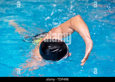 Swimming pool sport crawl swimmer. Man doing freestyle stroke technique in water pool lane training for competition . Stock Photo