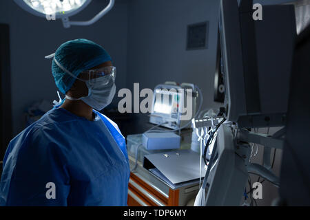 Female surgeon looking at monitor in operation theater Stock Photo