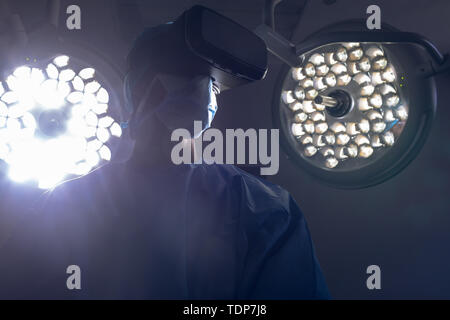 Male surgeon using virtual reality headset in operating room at hospital Stock Photo