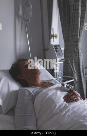 Female patient sleeping in bed in the ward at hospital Stock Photo