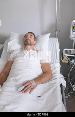 Male patient sleeping in bed in the ward Stock Photo