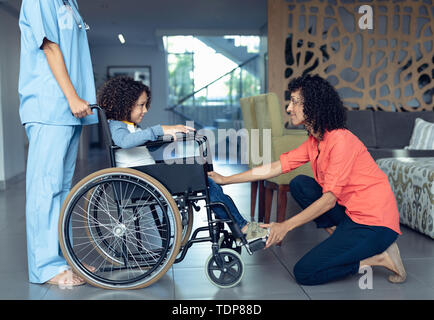 Mother consoling her disabled son in the lobby at hospital Stock Photo